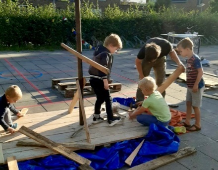 Kinderen die een vlot aan het bouwen zijn met hout